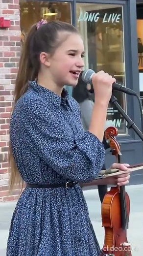 Karolina Protsenko talks to the crowd before her Violin Cover