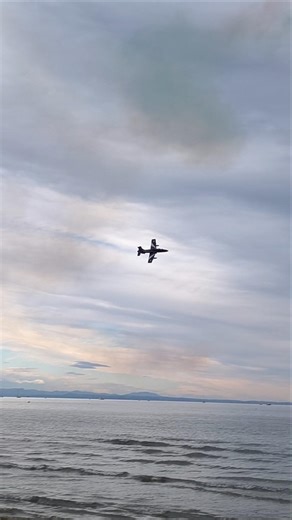 Jet airplane flying very low over the sea & roll