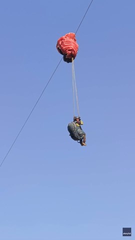 Paraglider ends up hanging from power line during practice