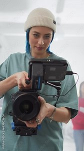 Vertical Screen: Slow Motion Shot of Female Cinematographer Working On a Filming Set, Using Digital Camera to Shoot High-Quality Footage for Cinematic Project. Creative Woman Operating a Camera
