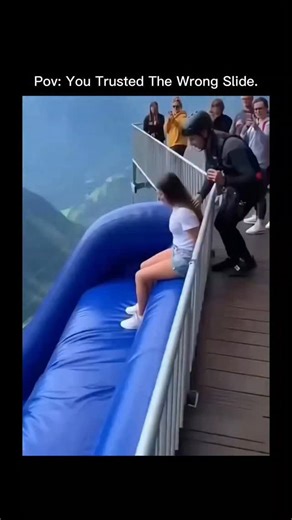 coolwar.io on Instagram: "The post features an AI-generated video from Invideo depicting a woman sliding down a massive inflatable slide over a misty mountain cliff without harnesses, capturing a thrilling 18-meter freefall bounce that evokes intense adrenaline. Japanese text humorously ponders the rider's emotions during the unsafe descent, resonating with viewers for its mix of awe and terror, amassing nearly 3 million views and 449 replies within hours."