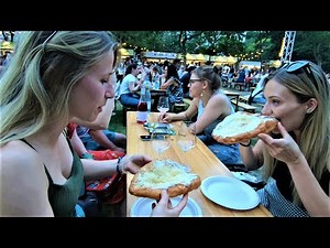 Street Food in Budapest, Hungary. Preparing, Cooking and Eating Traditional 'Langos'