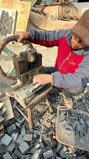 Cutting small dark gray stone tiles with a manual press machine for building and design projects