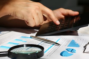 Black calculator and financial statistics on infographics at office...