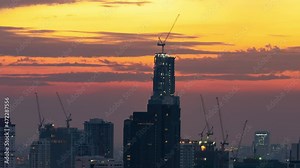 Time-lapse of skyscraper tower buildings in Asia downtown city, crane working, sunset silhouette cityscape. Construction industry, industrial business, or civil engineering technology concept