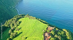 Drone flies backward over Stunning lush ridge from Ponta da Madrugada Viewpoint by Atlantic Ocean, Azores