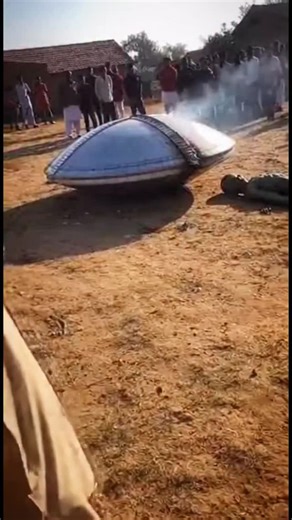 Shawn Arranha on Instagram: "👽 SHOCKING! UFO Crash and Alien Sighting in Indian Village! 🛸 A small village in India was thrown into chaos this afternoon after what appears to be a genuine UFO crash landing right in the middle of a field! Witnesses captured this incredible footage showing a silver, disc-shaped craft buried in the dirt, still smoking. But that’s not the most unbelievable part... Lying unconscious next to the wreckage is a strange, greyish-green figure—an alien! The entire villag