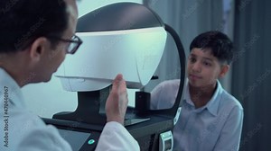 Boy doing eye test checking examination with autorefractor in optical shop, Optometrist doing sight testing for child patient, Eye doctor examinating kid patient