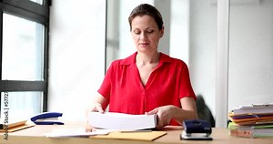 Beautiful woman portrai. In office holding stack white sheets paper on table