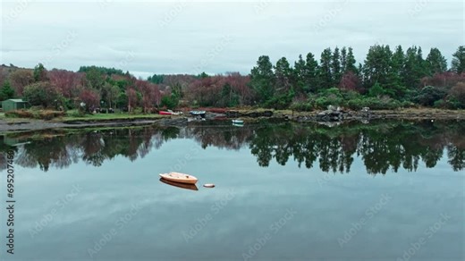 Sneem Ring Of Kerry Ireland wild Atlantic way early autumn morning still waters in a harbour with a boat and shadows of trees on the water