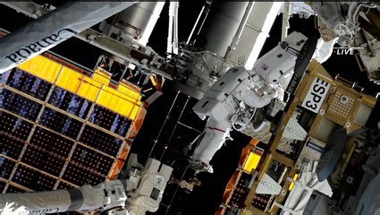Spacewalkers installing roll out solar array at space station