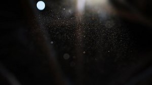 Beautiful shine Floating Dust Particles with Flare on Black Background in Slow Motion. video of Dynamic Wind Particles In The Air With Bokeh