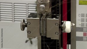 Strength test of a wire sample. Rollers of tension of the explosive car. Tensile machine of steel wire