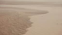 Close-up shot of sand. The texture of sand, grains of sand fly blown...