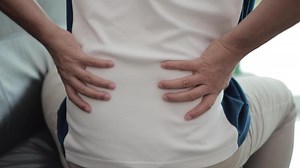 Download back pain, back massage, man's hands massaging his own back, hand massaging pain for free