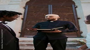 The priest gives the bride and groom wedding rings standing in front of the church at an outdoor wedding