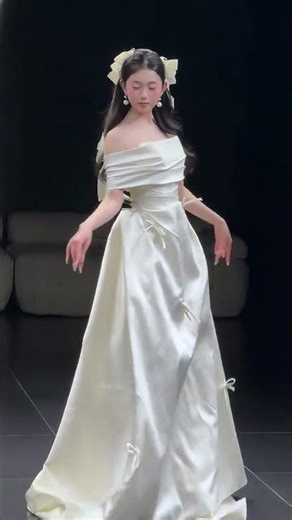 一字領露肩設計，把肩頸線條襯得絕美 腰腹的收褶+蝴蝶結綁帶，巨顯腰細！ 垂墜感滿滿的緞面，走動間自帶柔光濾鏡 搭配同色系蝴蝶結髮飾，溫柔感直接拉滿 是一眼心動的可愛優雅，婚禮穿這套吧~👰‍♀