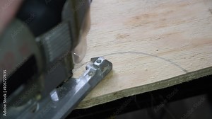 Electric fretsaw is sawing plywood. Close-up