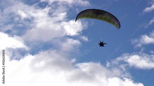 Capture breathtaking footage as the camera expertly follows a pilot and passenger on an exhilarating tandem paragliding adventure.