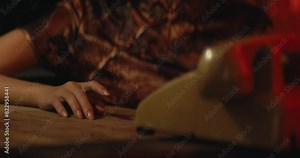 female hand finger knocking on table while waiting for a call from old vintage retro phone, wearing traditional asiatic chinese style dress