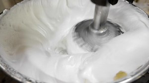 Automatic production of cream in the production of sweets. The mixer whips the cream mass
