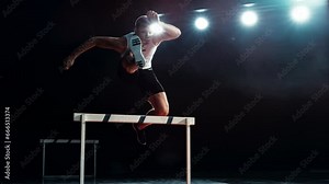 Strong Male Athlete is Running Towards an Obstacle, Hurdling, Jumping Over the Barrier at High Speed while Sprinting in a Race. Cinematic Super Slow Motion Footage with Speed Ramp Effect