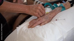 A nurse setting up an IV on an elderly patient