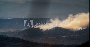 Firefighter airplane drops water on to the burning mountain forest in slow motion. Wildfire in natural parkland on summer. Ecology pollution catastrophe. Strong smoke in flaming forest. Manresa, Spain Stock Video