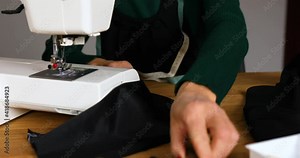 Step by step, 50-yers old woman sews clothes on sewing machine