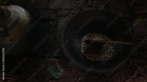 Coffee beans production roast process in indonesian village. The coffee beans are roasted on the fire in a pottery stirring