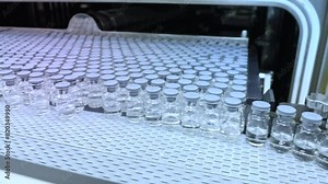 Lyophilization. vaccine vials entering lyophilizer, lyophilized vaccine freeze dr injection medicine fill glass vials entering, freeze drying process in a medicine manufacturing factory