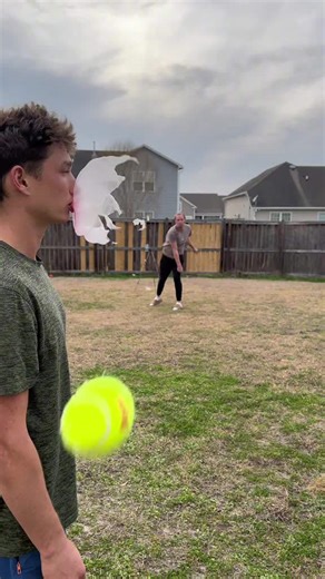 Slow motion tennis ball pops giant bubble gum bubble