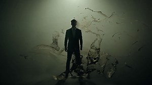 Businessman in a suit emerges from an abstract form of dark ink cascading down, creating a sense of magic and mystery | Premium Stock Video Footage