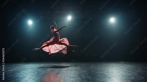 Young graceful classical ballet female dancer in tutu is performing choreography on stage. Ballerina makes difficult pirouette on stage