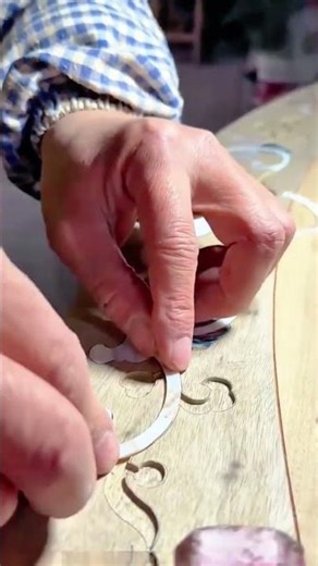 Applying intricate shell inlays to a decorative wooden surface
