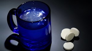 Tablet dissolving in a blue glass of water