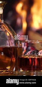 Luxury brandy and drop in glass of cognac. Glass with golden cognac on isolated black background with smoke. Brandy, cognac, and whisky. Slow motion. Luxury Drink Whisky with smoke.