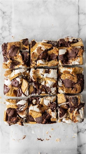 These smores cookie bars melt in your mouth! Crispy graham crackers, chocolate, and marshmallows - baked into a delectable cookie bar! | The Scran Line