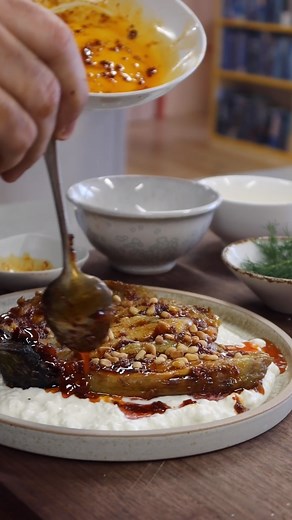 Burnt aubergine: our way! An easy technique using a very hot griddle pan, served with feta and harissa oil. Find the full recipe here: https://bit.ly/2NFDxLl | Ottolenghi