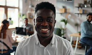 A young professional smiles warmly while engaged in a dynamic discussion with colleagues in a collaborative workspace