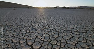 Climate change.Tilt-down close-up view of patterned cracked mud surface of a dry dam due to drought from climate change and global warming