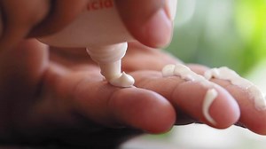 Download Applying sunscreen cream on hand to nourish skin in sunny location for free