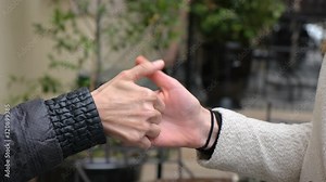 two women playing Thumb war finger wrestling. Close up of hands having a thumb war.