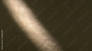 Water surface ripples and splashes, bright light and shadow on dark sand texture