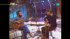 735K views · 15K reactions | SUR LA ROUTE 麟Retrouvons deux icônes de la musique folk, Graeme Allwright et Maxime Le Forestier, pour une interprétation accoustique toute en douceur de la ballade "Emmène-moi" en 1980. "Mon coeur est triste et j'ai mal aux pieds..." | INA | Facebook