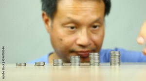 Man putting coins to stacking for money saving profit and business investment growth concept.
