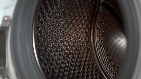 clip-3998761095-young-woman-putting-clothes-into-washing-machine