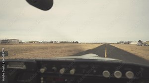 View from the interior of a small plane moving along a runway of an airport