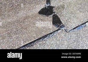 Slow motion footage showing detailed bitumen membrane joint during waterproofing process, emphasizing texture, layers, adhesive bonding and structural protection