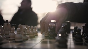Playing chess on the street. Player moves the black pieces.